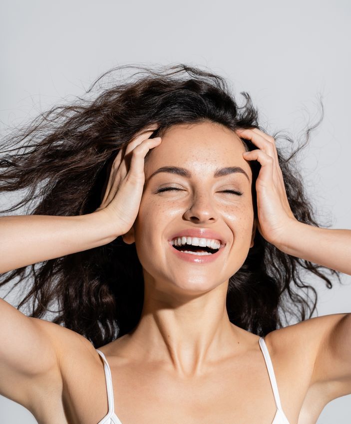 Crown Point Chemical Peel model with wind-blown hair smiling